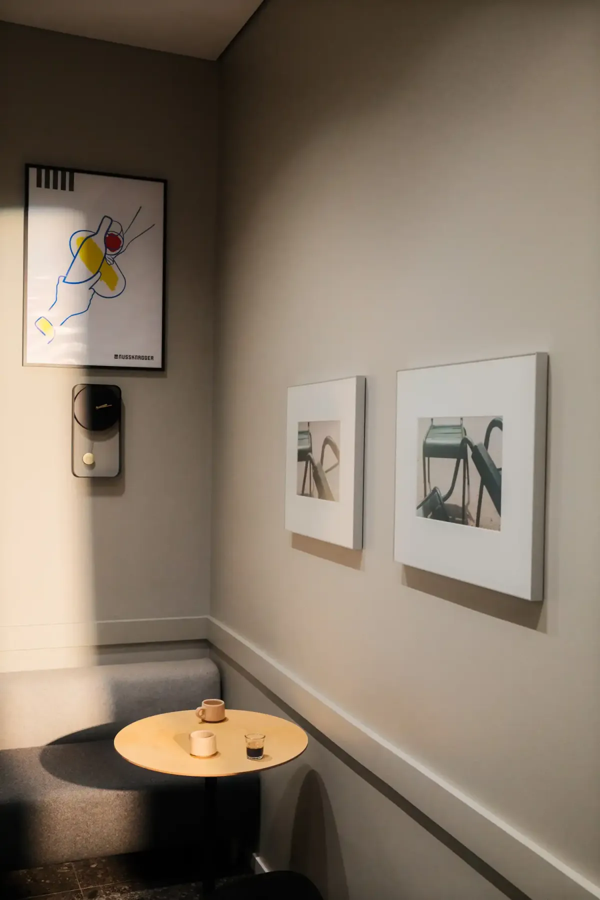 Cosy seating area with round wooden table, nussknagger poster and framed photographs
